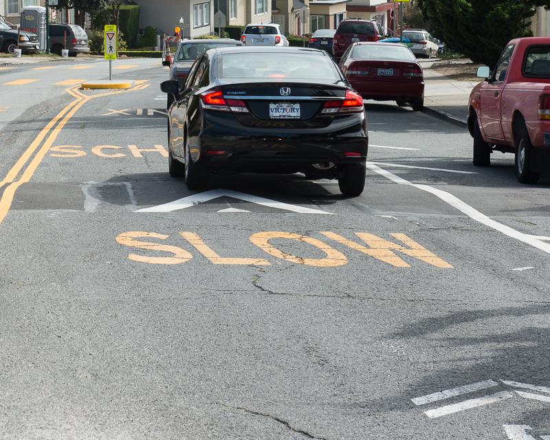 Car driving over speed hump in school zone