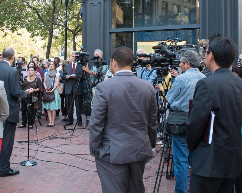 group of news camera people at press event on market street