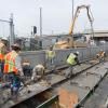 Workers traverse the site carefully during the last of the tunnel portal invert concrete pour, completing the foundation and roa