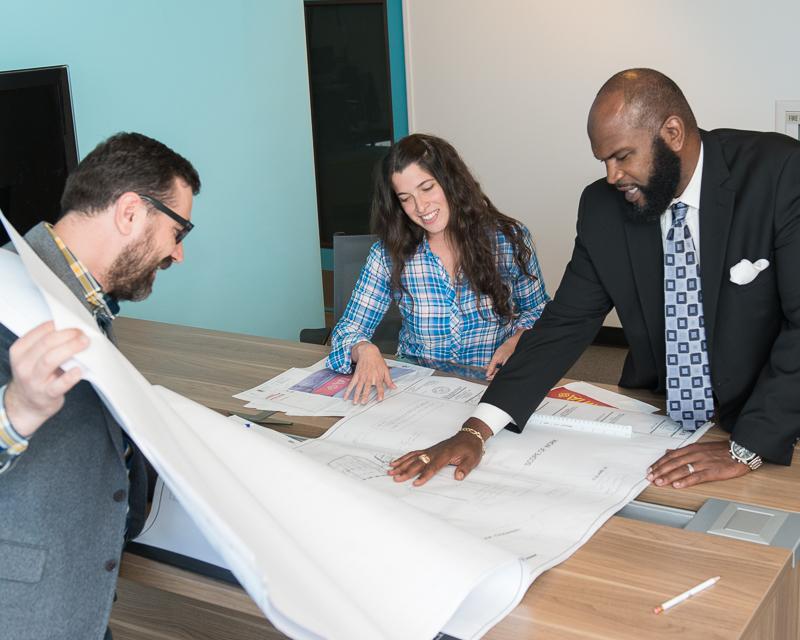 group of people looking at drawings on table