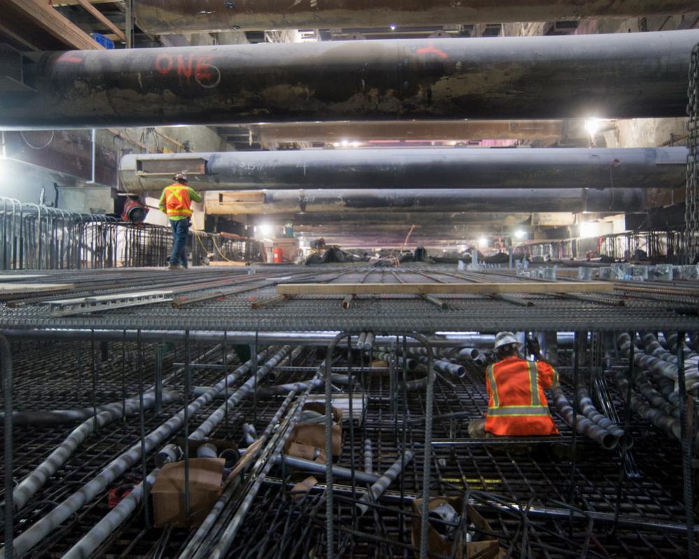 A worker walks atop the rebar cage of the invert slab at the north end of the Union Square/Market Street station box.