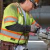 A carpenter cuts a 2x4 as part of concrete form assembly inside the YBM station headhouse.