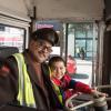 An operator and his son sit on a historic bus