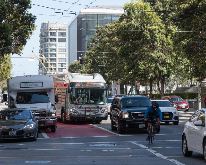 30 Stockton bus traveling north on Third Street. Driving in the red transit lane, the bus is blocked by vehicles turning right.