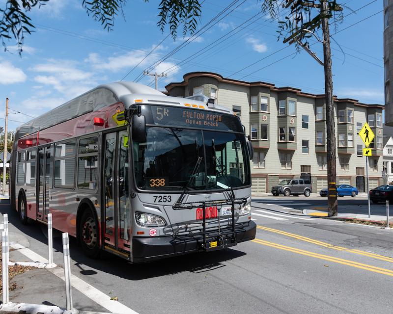 A photograph of the 5R  Fulton Rapid driving through the intersection of McAllister and Lyon streets in San Francisco.