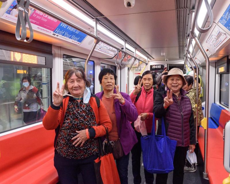 Image of Muni Metro riders smiling at the camera