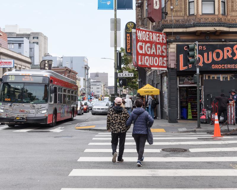 Two pedestrians using crosswalk to corss Geary street at Larkin 