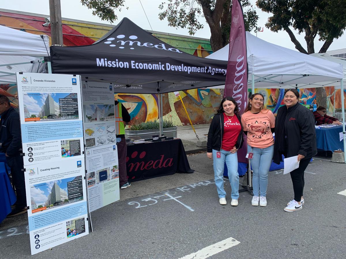 A group of people standing in front of a tent with booth