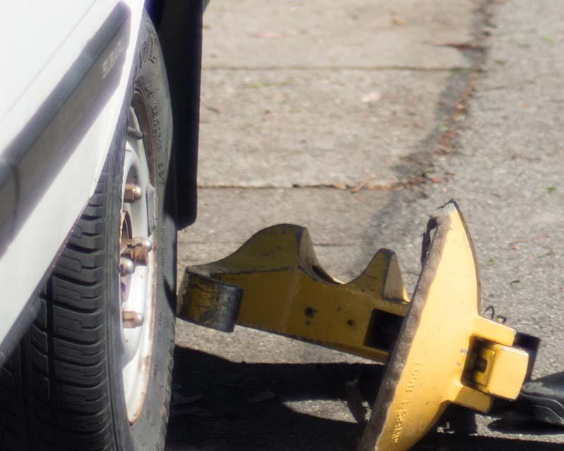 A booting device next to a car's tire