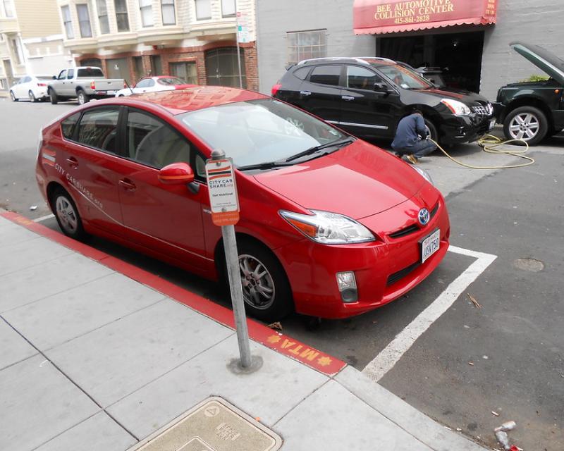 A shared vehicle parked at a permitted car share only curbside parking space.