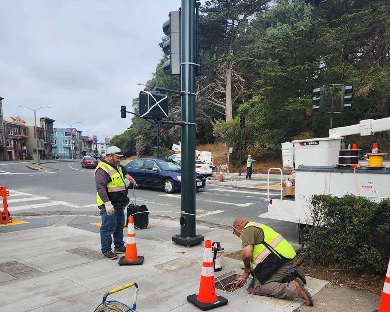 Electricians wiring recently installed traffic signals at Kezar Dr and Lincoln Way