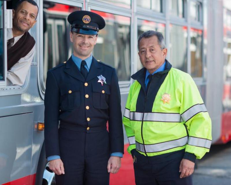 Muni employees stand beside bus