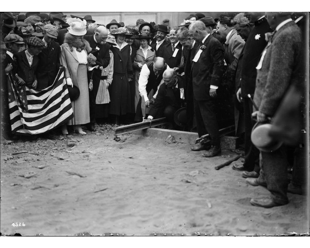 Mayor James Rolph Driving Ceremonial Spike for First Track Laid at the West Portal of the Twin Peaks Tunnel with Large Crowd | F