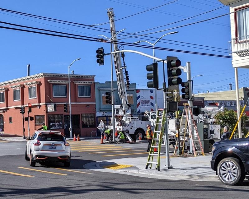 Crane installing new traffic signals at Geneva and Naples