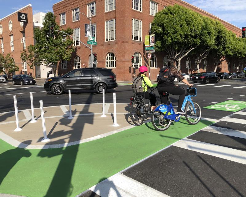 image of two people bicycling across the 7th Street & Townsend Street intersection