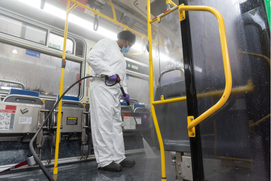 Muni Employee sanitizing a Muni vehicle with a sprayer