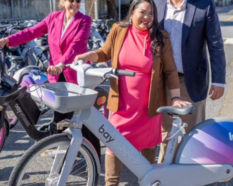 Daly City Mayor Juslyn Manalo and others smile at a new bikeshare station at Daly City BART.